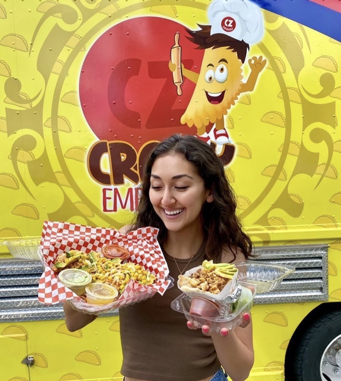 Happy customer holding Crazy Empanadas dishes in front of the food truck