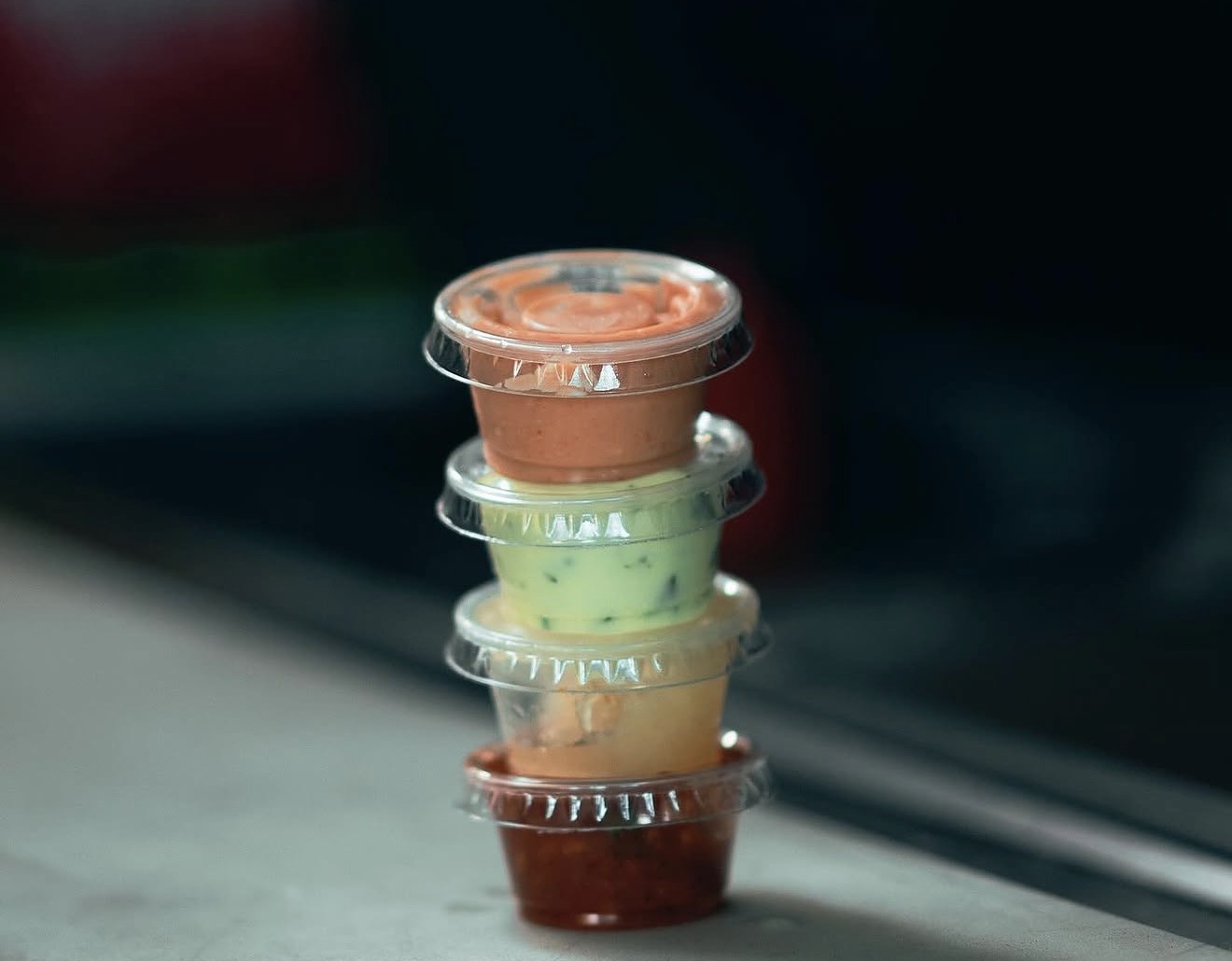Our homemade sauces stacked up — pink, green, and ají